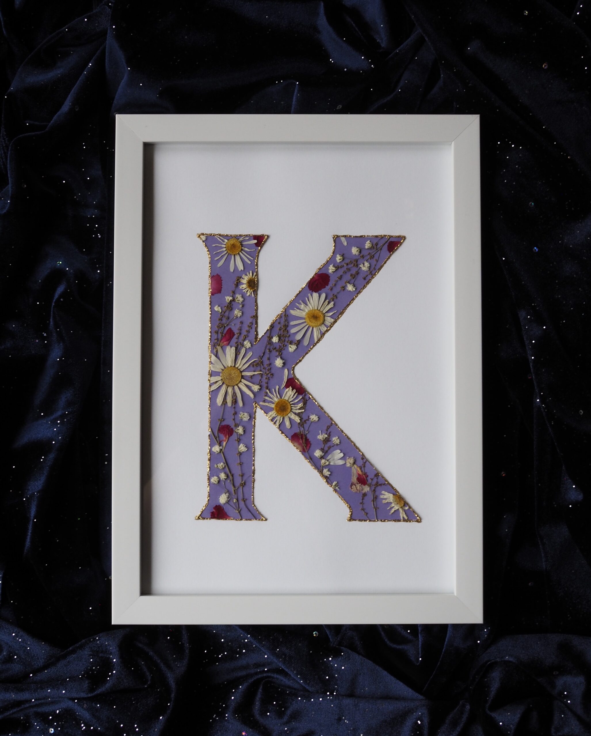 Kirjaintaulu prässätyistä kukista